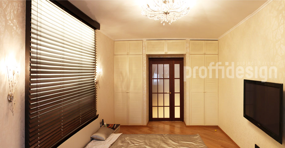 Спальня с витражной стеной и встроенным шкафом с дверцами жалюзи